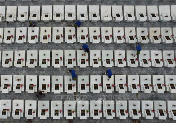 Thanh niên tình nguyện chăm sóc mộ phần các liệt sĩ đang yên nghỉ tại Nghĩa trang liệt sĩ quốc gia Vị Xuyên. Ảnh: Hoàng Hiếu - TTXVN