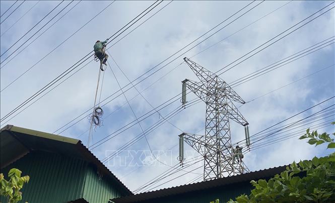 Đơn vị thi công tiến hành kéo dây đường dây điện dự án “Công trình đường dây 220kV Nhiệt điện Hải Dương – Trạm 500kV Phố Nối đoạn qua thôn Đồng Xuyên, thôn Hộ Vệ và thôn Đông Đồng, xã Cẩm Hưng, huyện Cẩm Giàng. Ảnh: TTXVN phát
