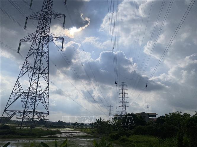 Đơn vị thi công tiến hành kéo dây đường dây điện dự án “Công trình đường dây 220kV Nhiệt điện Hải Dương – Trạm 500kV Phố Nối đoạn qua thôn Đồng Xuyên, thôn Hộ Vệ và thôn Đông Đồng, xã Cẩm Hưng, huyện Cẩm Giàng. Ảnh: TTXVN phát
