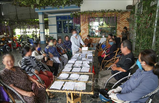 Nhiều người dân với giấy biên nhận nợ của tiệm vàng Xuân Hoa. Ảnh: Giang Phương - TTXVN