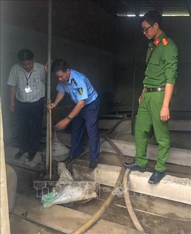 Cơ quan chức năng kiểm tra bồn chứa xăng của Doanh nghiệp tư nhân H.S. Ảnh: TTXVN phát