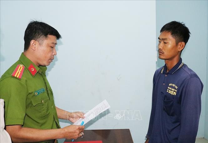 Lực lượng chức năng thi hành quyết định tạm giữ hình sự đối với Trần Thanh Hòa. Ảnh: TTXVN phát