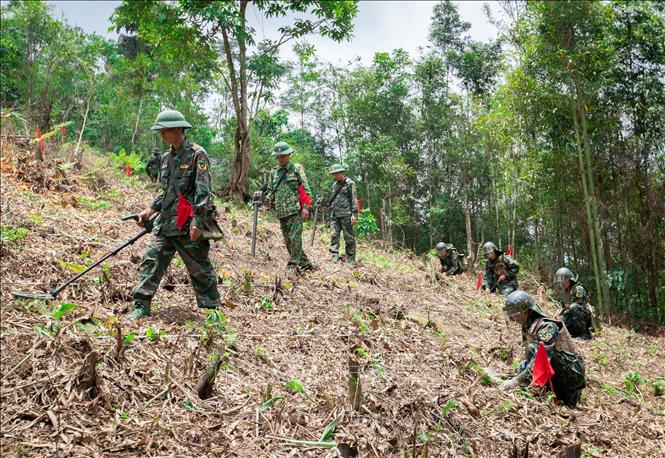Cán bộ, chiến sĩ, công nhân quốc phòng phải luôn cẩn thận trong từng bước tìm kiếm, dò, gỡ bởi bom, mìn, vật liệu nổ bị vùi lấp lâu năm trong đất, qua tác động của môi trường và vật chất xung quanh luôn trong trạng thái sẵn sàng nổ. Ảnh: Hoàng Hiếu – TTXVN
