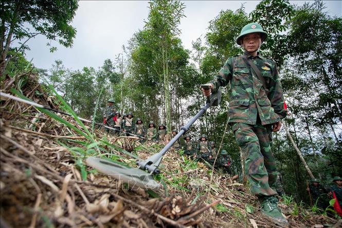 Ðể làm sạch hoàn toàn bom, mìn, cán bộ, chiến sĩ thực hiện rà phá bom mìn vật nổ bằng máy dò, gỡ mìn đến độ sâu 30 cm, rồi lại tiếp tục dò, tìm đến độ sâu 3m. Ảnh: Hoàng Hiếu – TTXVN