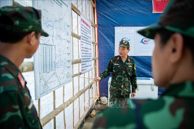 Trung tá Nguyễn Thành Nam, Đội trưởng Đội rà phá bom mìn, Công ty xử lý bom mìn, vật nổ 319 (Bộ Quốc phòng) xác định, quán triệt khu vực rà phá bom, mìn cho các đội tìm kiếm. Ảnh: Hoàng Hiếu – TTXVN