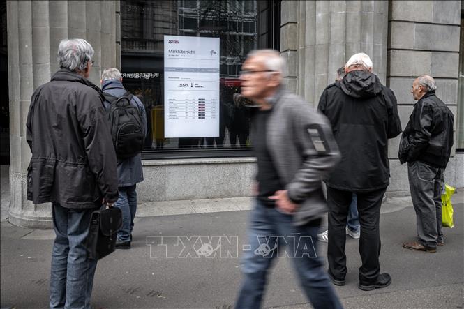 (Tư liệu) Người dân chờ đợi bên ngoài một chi nhánh ngân hàng ở Zurich, Thụy Sĩ. Ảnh: AFP/TTXVN