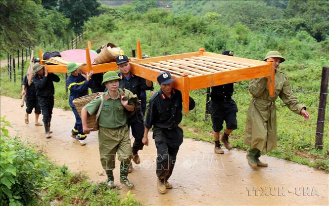 Chiến sỹ công an và cảnh sát cơ động tỉnh Lai Châu giúp bà con di chuyển đồ đạc đến nơi an toàn do ảnh hưởng của mưa lũ. Ảnh: Công Tuyên - TTXVN
