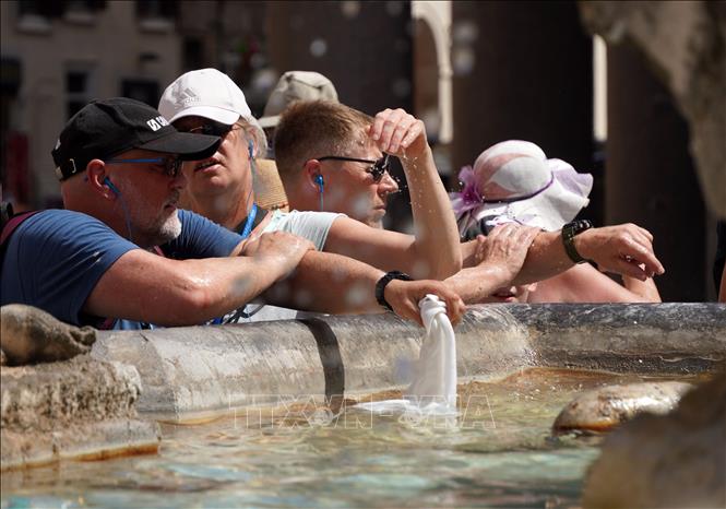 Người dân tránh nóng bên đài phun nước tại Rome, Italy, ngày 18/7/2023. Ảnh: THX/TTXVN
