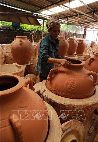 Hoàn thiện sản phẩm gốm trước khi đưa vào lò nung ở làng nghề gốm thủ công mỹ nghệ Vĩnh Hồng, phường Mạo Khê, thị xã Đông Triều. Ảnh: Vũ Sinh - TTXVN