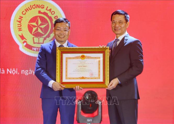 Bộ trưởng Bộ Thông tin và Truyền thông Nguyễn Mạnh Hùng tặng Bằng khen của Thủ tướng Chính phủ cho Phó Cục trưởng Cục Báo chí Đặng Khắc Lợi. Ảnh: Tuấn Đức - TTXVN