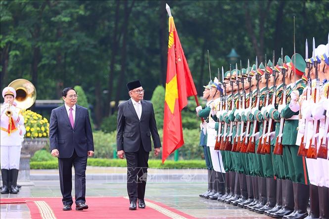 Prime Minister Pham Minh Chinh and Malaysian Prime Minister Anwar Ibrahim reviews the guards of honour at the welcome ceremony. VNA Photo: Dương Giang