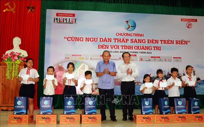 Nguyên Ủy viên Bộ Chính trị, nguyên Phó Thủ tướng Thường trực Chính phủ Trương Hòa Bình trao tặng quà cho học sinh con em ngư dân. Ảnh: Nguyên Linh-TTXVN