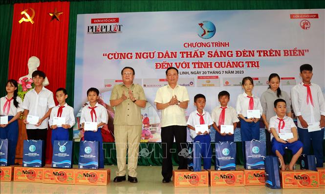 Ông Hà Sỹ Đồng, Phó Chủ tịch Thường trực UBND tỉnh Quảng Trị và ông Nguyễn Đức Lợi, Phó Chủ tịch Thường trực Hội Nhà báo Việt Nam trao tặng quà cho học sinh là con em ngư dân. Ảnh: Nguyên Linh-TTXVN