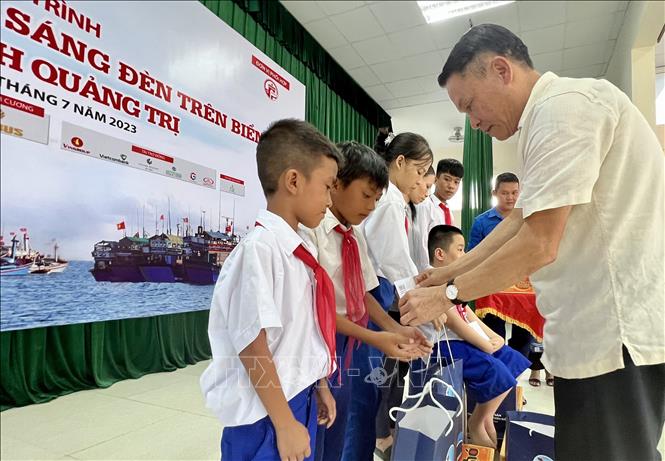 Ông Nguyễn Đức Lợi, Phó Chủ tịch Thường trực Hội Nhà báo Việt Nam trao học bổng cho con em ngư dân ở thị trấn Cửa Việt, huyện Gio Linh, tỉnh Quảng Trị. Ảnh: Nguyên Linh-TTXVN