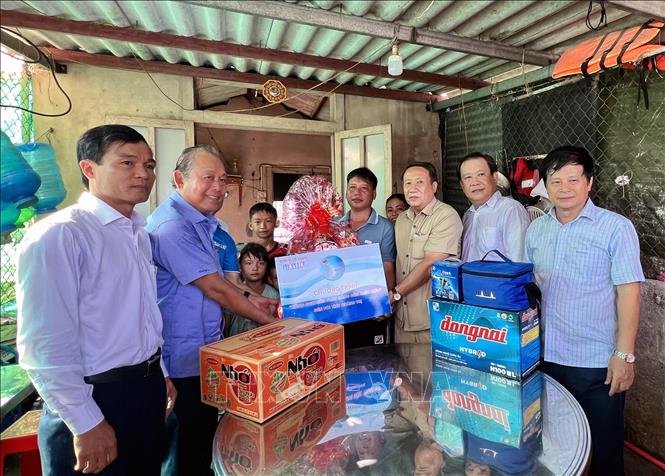 Nguyên Ủy viên Bộ Chính trị, nguyên Phó Thủ tướng Thường trực Chính phủ Trương Hòa Bình cùng Ban tổ chức trao quà cho gia đình ngư dân Hồ Văn Sơn ở thị trấn Cửa Việt, huyện Gio Linh, tỉnh Quảng Trị. Ảnh: Nguyên Linh-TTXVN