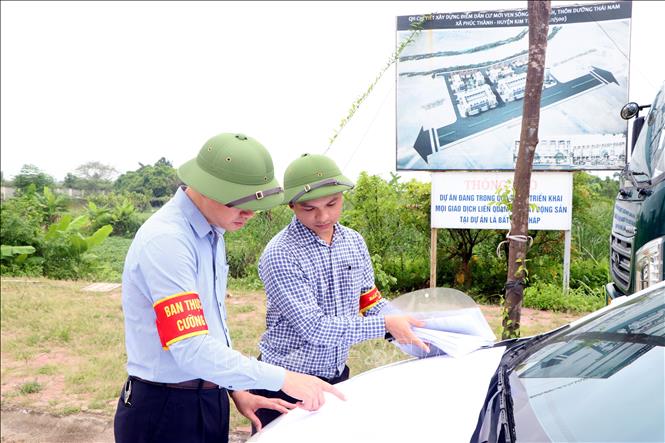 Trong ảnh: Ban thực hiện cưỡng chế thu hồi đất tiến hành cưỡng chế, thu hồi đất của 2 hộ dân không chấp hành quyết định. Ảnh: Mạnh Tú - TTXVN
