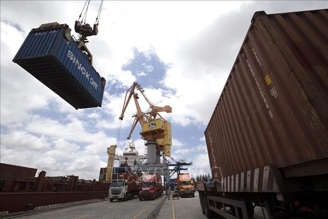 Các container được bốc xếp từ xe chở chuyên dụng lên tàu chở hàng. Ảnh: Tuấn Anh - TTXVN