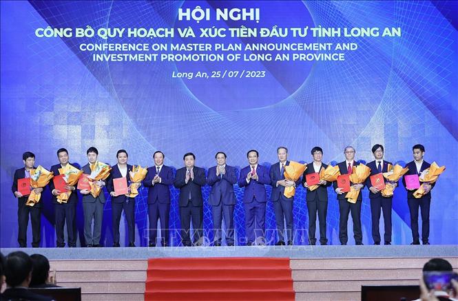 Thủ tướng Phạm Minh Chính chứng kiến trao chứng nhận đăng ký đầu tư của tỉnh Long An cho các nhà đầu tư. Ảnh: Dương Giang-TTXVN
