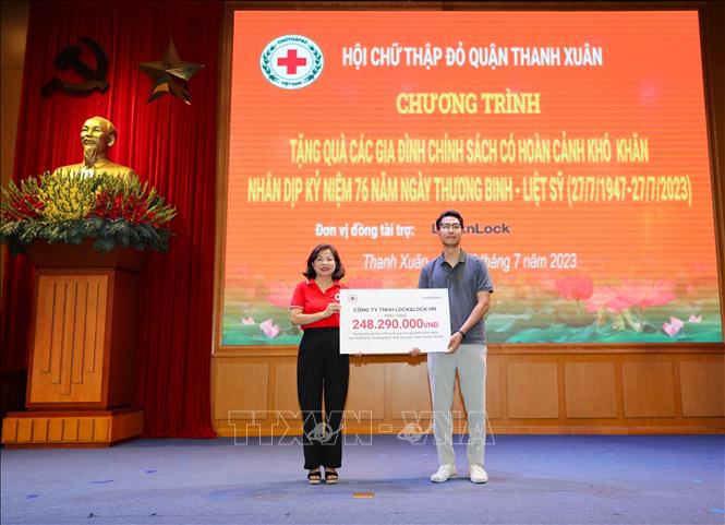 Đại diện Công ty TNHH Lock&Lock trao tượng trưng hỗ trợ các phần quà tri ân dành tặng gia đình chính sách, có hoàn cảnh khó khăn cho Hội Chữ thập đỏ quận Thanh Xuân. Ảnh: Thanh Tùng - TTXVN 