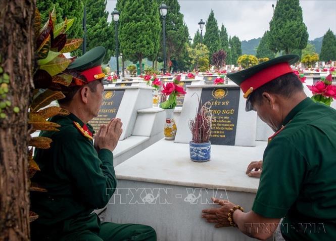 Các cựu chiến binh thắp hương tưởng nhớ đồng đội hy sinh tại Nghĩa trang liệt sĩ quốc gia Vị Xuyên (Hà GIang). Ảnh: Nam Thái - TTXVN