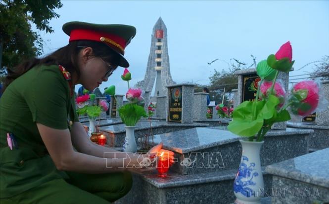 Thắp nến tri ân các liệt sĩ tại Nghĩa trang Liệt sĩ tỉnh Hậu Giang. Ảnh: Duy Khương - TTXVN