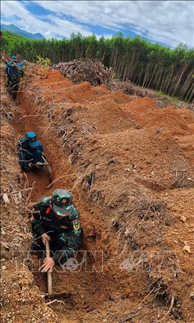 Cán bộ chiến sỹ thực hiện tìm kiếm ở khu vực đồi Xuân Sơn. Ảnh: Sỹ Thắng-TTXVN