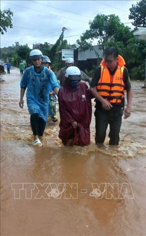 Trong ảnh: Chính quyền địa phương hỗ trợ sơ tán người dân khỏi khu vực ngập lụt. Ảnh: TTXVN phát
