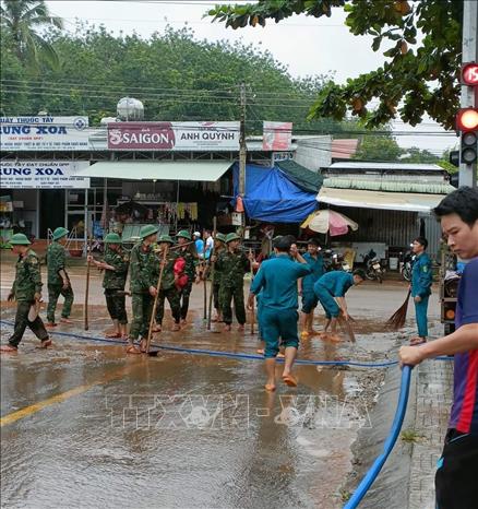Trong ảnh: Lực lượng chức năng hỗ trợ người dân khắc phục hậu quả lũ lụt. Ảnh: TTXVN phát
