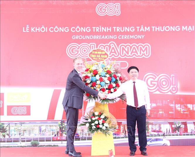 Chủ tịch UBND tỉnh Hà Nam Trương Quốc Huy tặng hoa chúc mừng lãnh đạo Tập đoàn Central Retail. Ảnh: Thanh Tuấn - TTXVN 