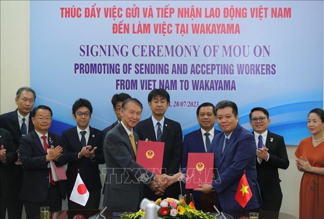 The signing of a Memorandum of Understanding on cooperation in basic legal framework between the Department of Overseas Labour Management of the Ministry of Labour, Invalids and Social Affairs and Wakayama prefecture. VNA Photo: Hoàng Hiếu