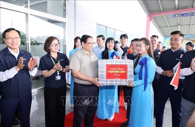 Thủ tướng Phạm Minh Chính tặng quà cho đại diện lãnh đạo, nhân viên Công ty TNHH Samsung Electronics Việt Nam. Ảnh: Dương Giang-TTXVN
