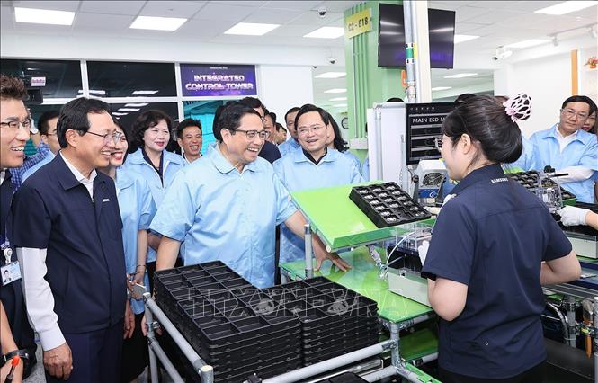 Thủ tướng Phạm Minh Chính thăm hỏi công nhân dây chuyền sản xuất thiết bị điện tử của Công ty TNHH Samsung Electronics Việt Nam. Ảnh: Dương Giang-TTXVN
