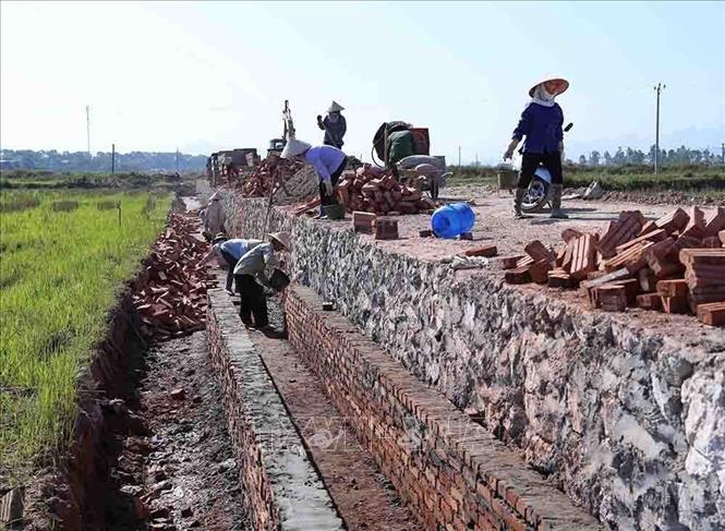 Kiên cố hóa kênh mương và làm đường giao thông nội đồng ở xã Đốc Tín, huyện Mỹ Đức được đầu tư xây dựng theo tiêu chí nông thôn mới. Ảnh: Vũ Sinh - TTXVN