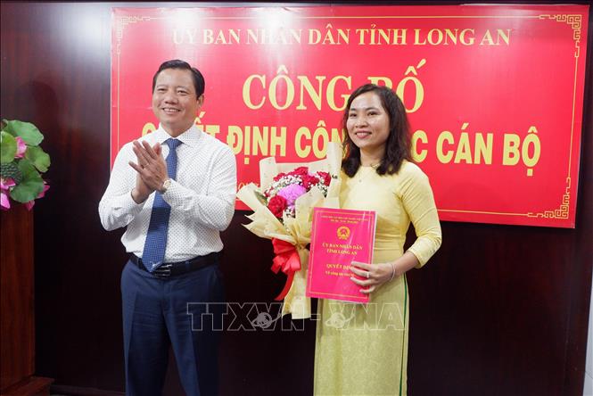 Phó Chủ tịch UBND tỉnh Long An Phạm Tấn Hòa trao quyết định cho bà Lê Thị Cẩm Tú. Ảnh: Đức Hạnh - TTXVN 