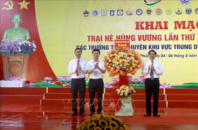 Giám đốc Sở Giáo dục và Đào tạo Vĩnh Phúc Nguyễn Văn Huyến (phải) tặng hoa chúc mừng Ban tổ chức Trại hè Hùng Vương lần thứ XVII. Ảnh: Hoàng Hùng -TTXVN