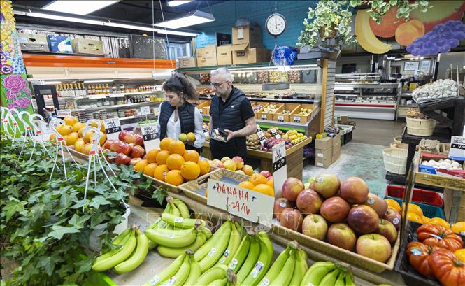 Người tiêu dùng chọn mua hàng tại một khu chợ ở Toronto, Canada. Ảnh: THX/TTXVN