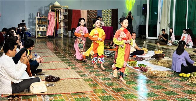 Người mẫu nhí trình diễn áo dài trên tân khấu tái hiện hình ảnh một khu chợ vùng thôn quê... Ảnh: Ánh Tuyết - TTXVN