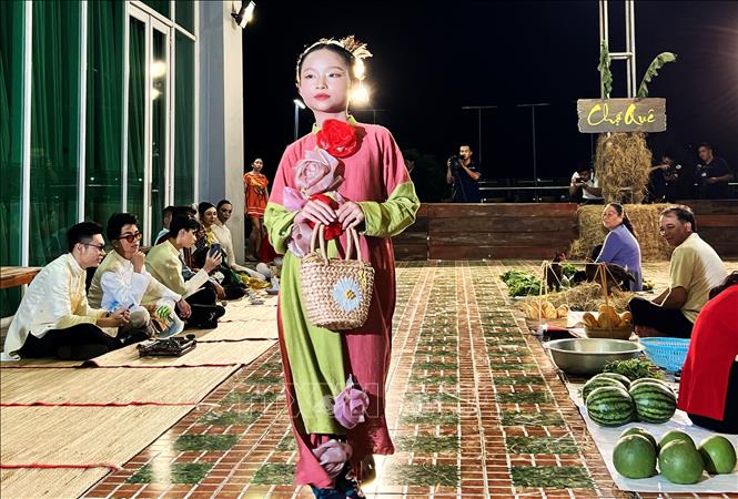 Người mẫu nhí trình diễn áo dài trên tân khấu tái hiện hình ảnh một khu chợ vùng thôn quê... Ảnh: Ánh Tuyết - TTXVN