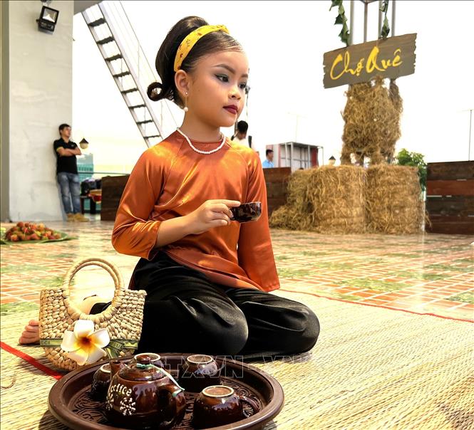Người mẫu nhí với bộ áo dài truyền thống. Ảnh: Ánh Tuyết - TTXVN