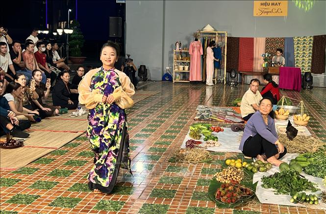 Người mẫu nhí trình diễn áo dài trên tân khấu tái hiện hình ảnh một khu chợ vùng thôn quê... Ảnh: Ánh Tuyết - TTXVN