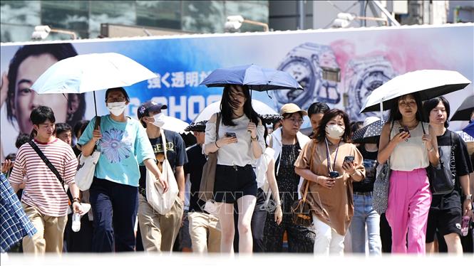 Người dân di chuyển dưới trời nắng nóng tại Tokyo, Nhật Bản ngày 27/7/2023. Ảnh: Kyodo/TTXVN