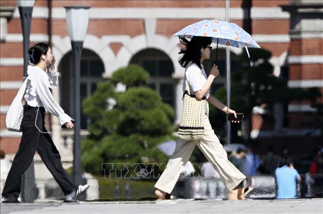 Người dân di chuyển dưới trời nắng nóng tại Tokyo, Nhật Bản ngày 17/7/2023. Ảnh: Kyodo/TTXVN