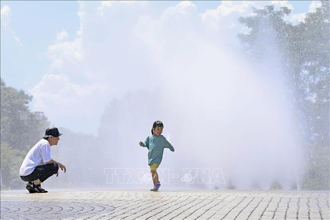 Một em nhỏ chơi đùa tại đài phun nước dưới trời nắng oi ả tại Nagoya, Nhật Bản ngày 27/7/2023. Ảnh: Kyodo/TTXVN