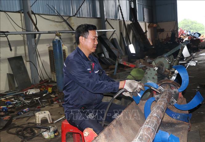 Anh Phùng Văn Nam hàng ngày cải tiến sản phẩm giàn máy cày phay lên luống giúp cải tiến năng suất lao động. Ảnh: Thanh Thương- TTXVN