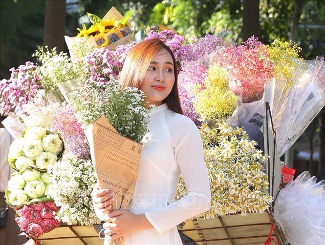 A girl with autumn's flowers. VNA Photo