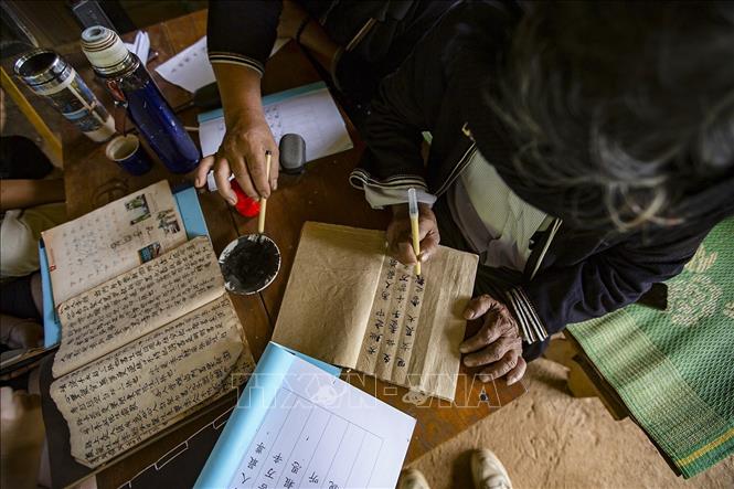Trong ảnh: Những khi rảnh rỗi, ông Lý Văn Hềnh miệt mài viết và biên soạn những bộ chữ viết của dân tộc Dao Tiền để truyền dạy cho con cháu và các học viên. Ảnh: Trọng Đạt - TTXVN
