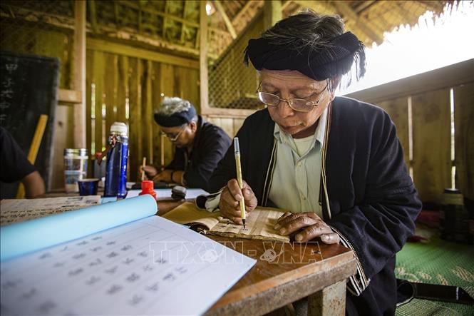 Trong ảnh: Những khi rảnh rỗi, ông Lý Văn Hềnh miệt mài viết và biên soạn những bộ chữ viết của dân tộc Dao Tiền để truyền dạy cho con cháu và các học viên. Ảnh: Trọng Đạt - TTXVN
