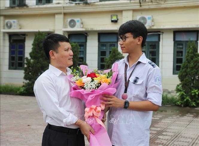 Thầy giáo chúc mừng em Trương Phi Hùng đã đoạt Huy chương Bạc Olympic Vật lí Châu Âu. Ảnh: Danh Lam - TTXVN