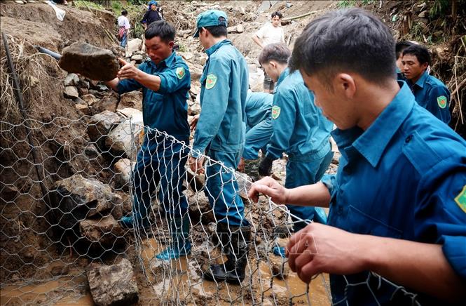 Lực lượng dân quân các xã và nhân dân tập trung khắc phục các tuyến đường bị sạt lở tại bản Đề Sủa, xã Lao Chải. Ảnh: Tuấn Anh - TTXVN