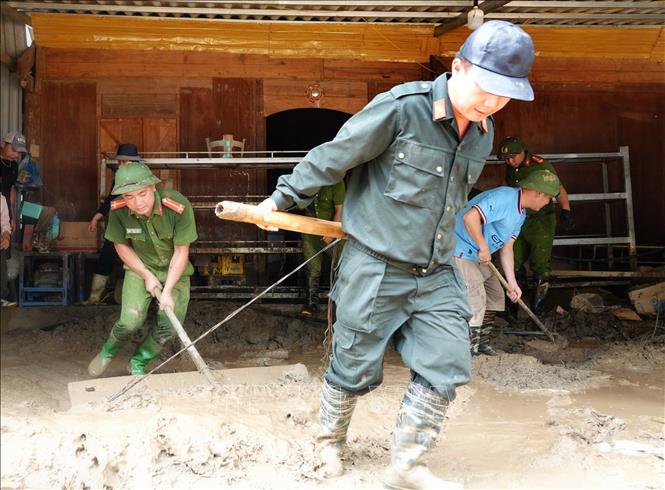 Lực lượng công an huyện Mù Cang Chải hỗ trợ các hộ dân xã Hồ Bốn dọn dẹp bùn đất sau thiên tai. Ảnh: Tuấn Anh - TTXVN